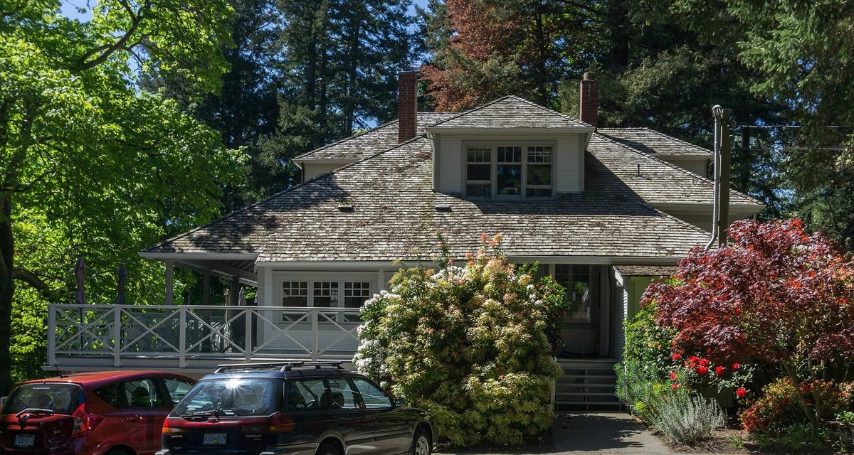 Weathered cedar shakes to standing seam metal, dark bronze, Saanich